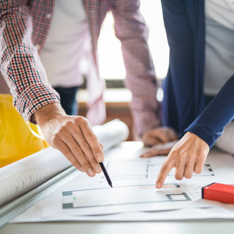 Hands working on a drafting table