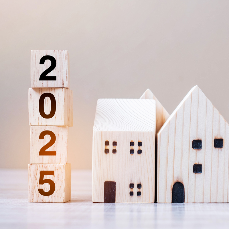 a stack of blocks that says 2025 next to a wooden house