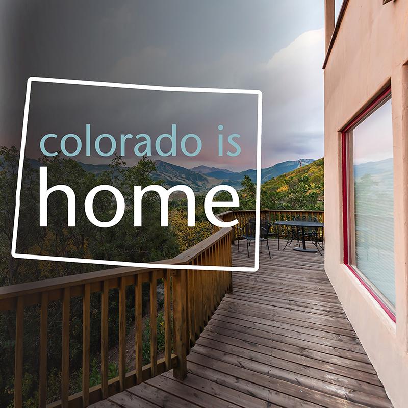 An upper floor balcony with a mountain view and text that reads colorado is home