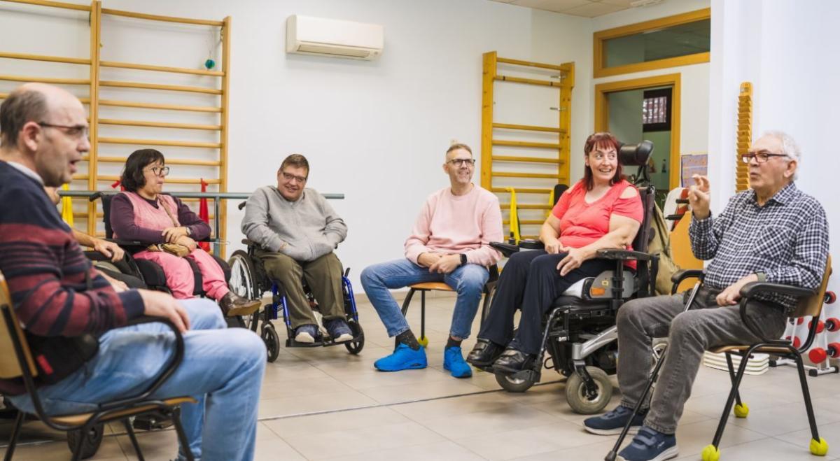 a group of people with physical disabilities sitting in a circle