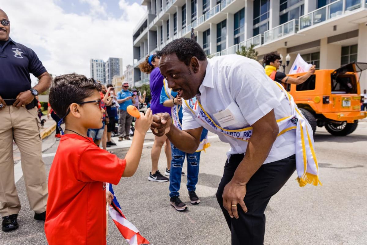 Orange County Mayor Jerry L. Demings meets a young resident during the Florida Puerto Rican Parade and Festival in April 2022.