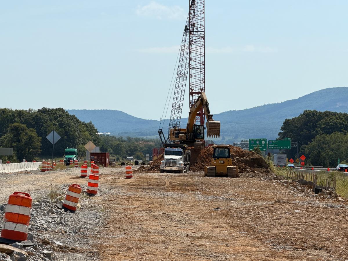 Work zone in the median of I-81 with construction equipment, barrels, and crane