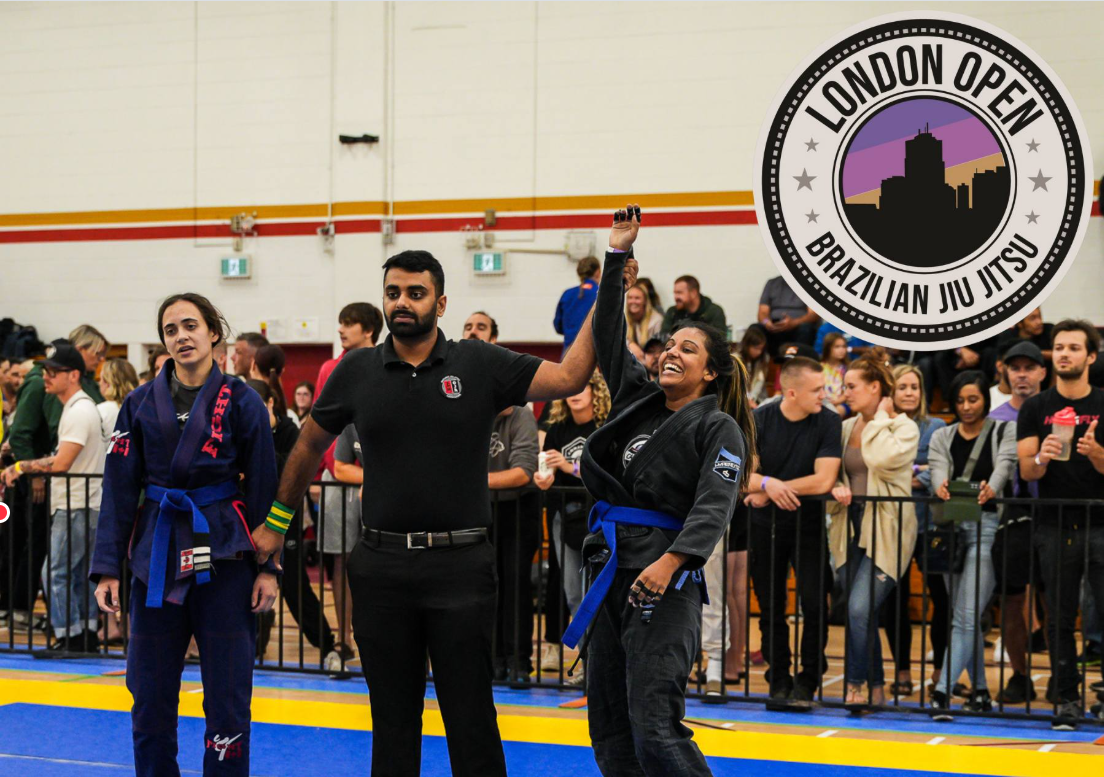 Competitors celebrate during the London Open Brazilian Jiu Jitsu tournament at RBC Place London, with spectators watching from behind the competition area.