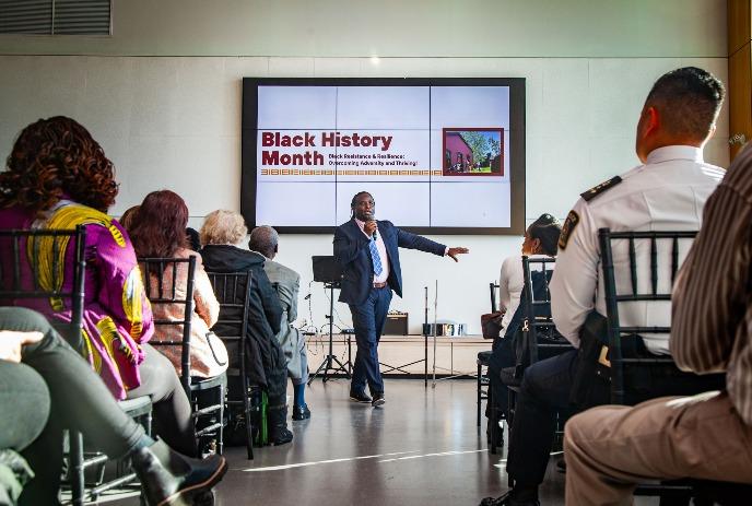 A speaker stands in front of a crowd during the Black History Month Opening Ceremonies at Museum London.