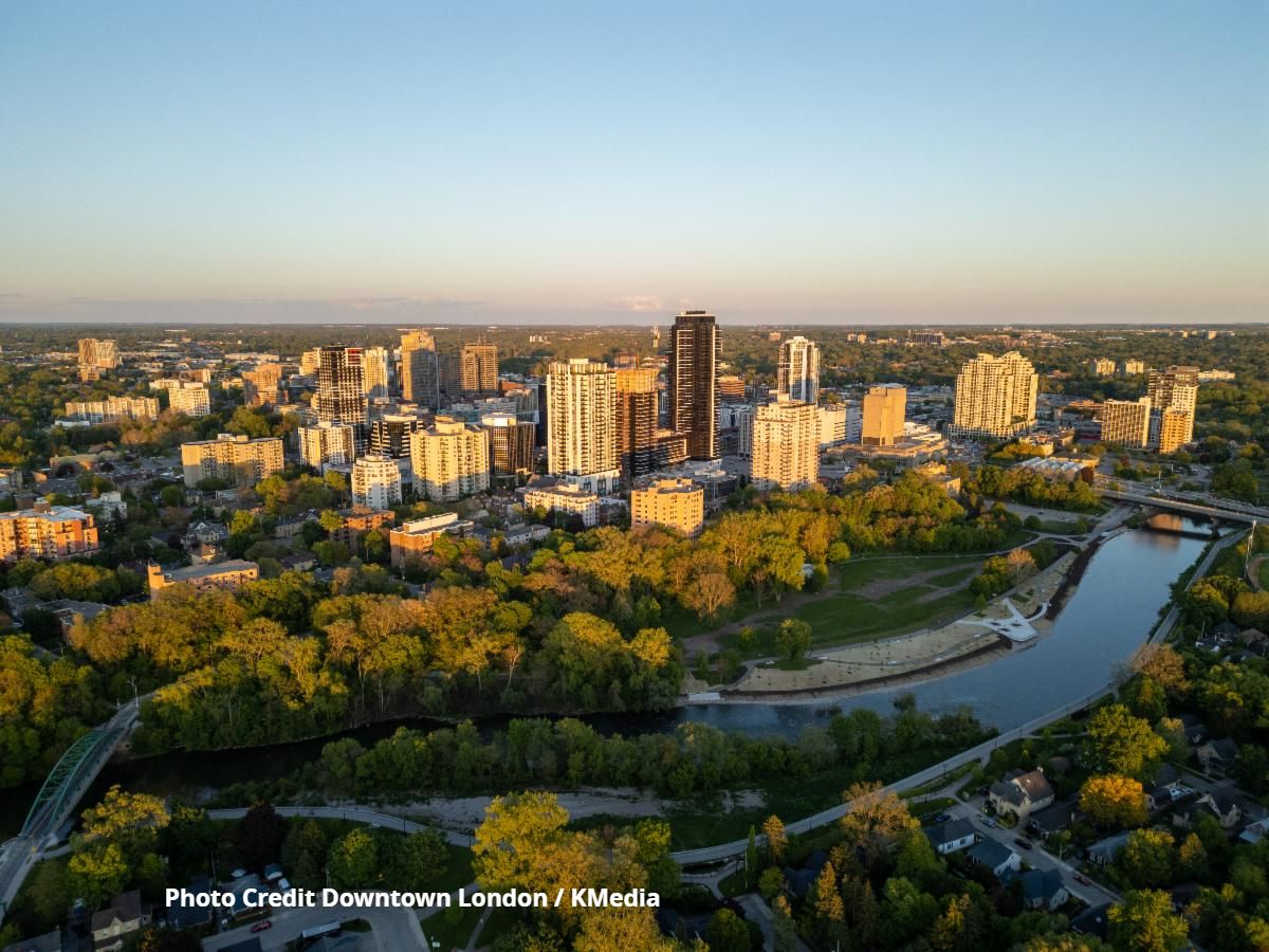 Aerial view of downtown London, Ontario, along the Thames River, with the city skyline, parkland and riverfront in the foreground. Photo Credit: Downtown London / KMedia
