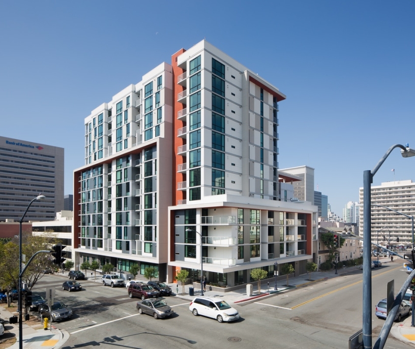 A tall white and red building with a street in the foreground.