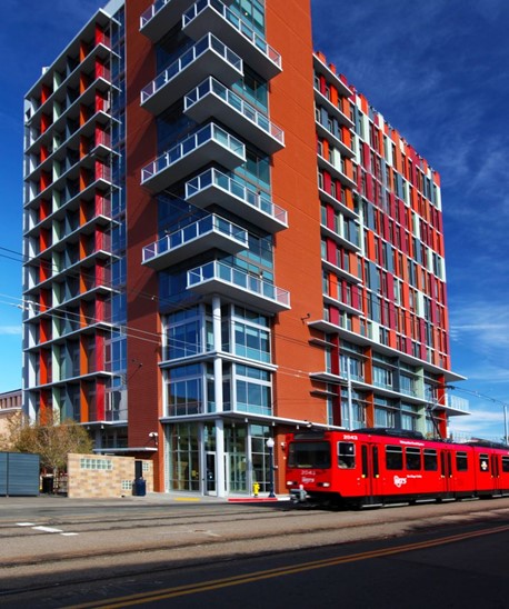 A red building with a red trolley stopped in the front of it