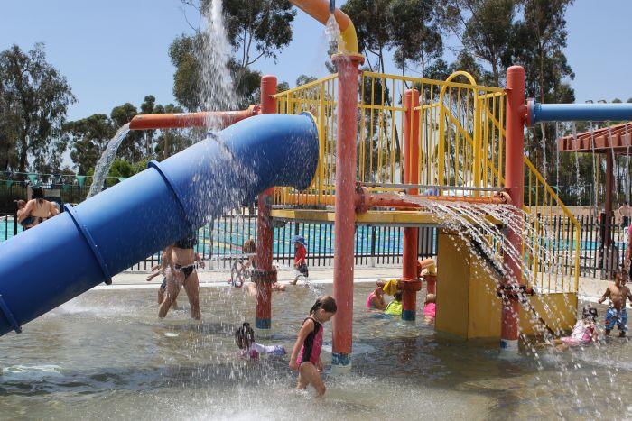 Children play in a splash pad and park