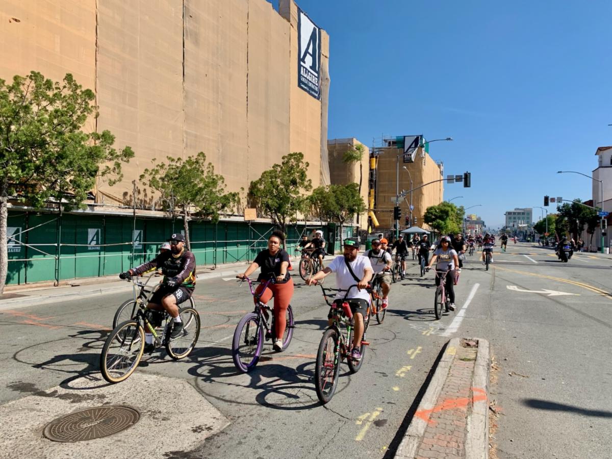 Bike riders roll through a street