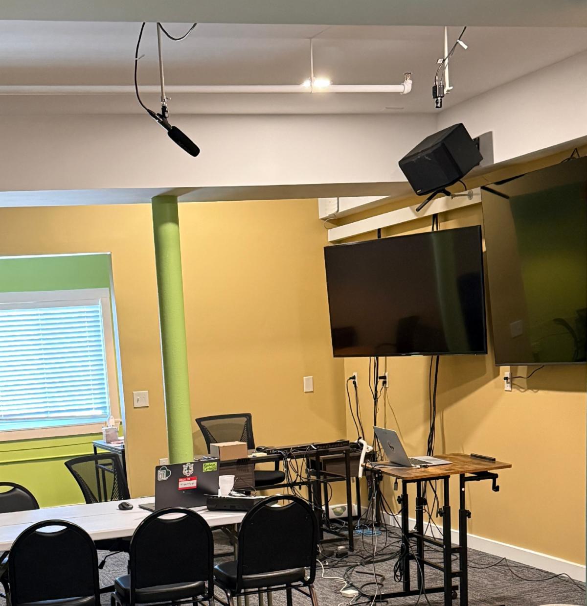 A classroom with two screens and built-in microphone.