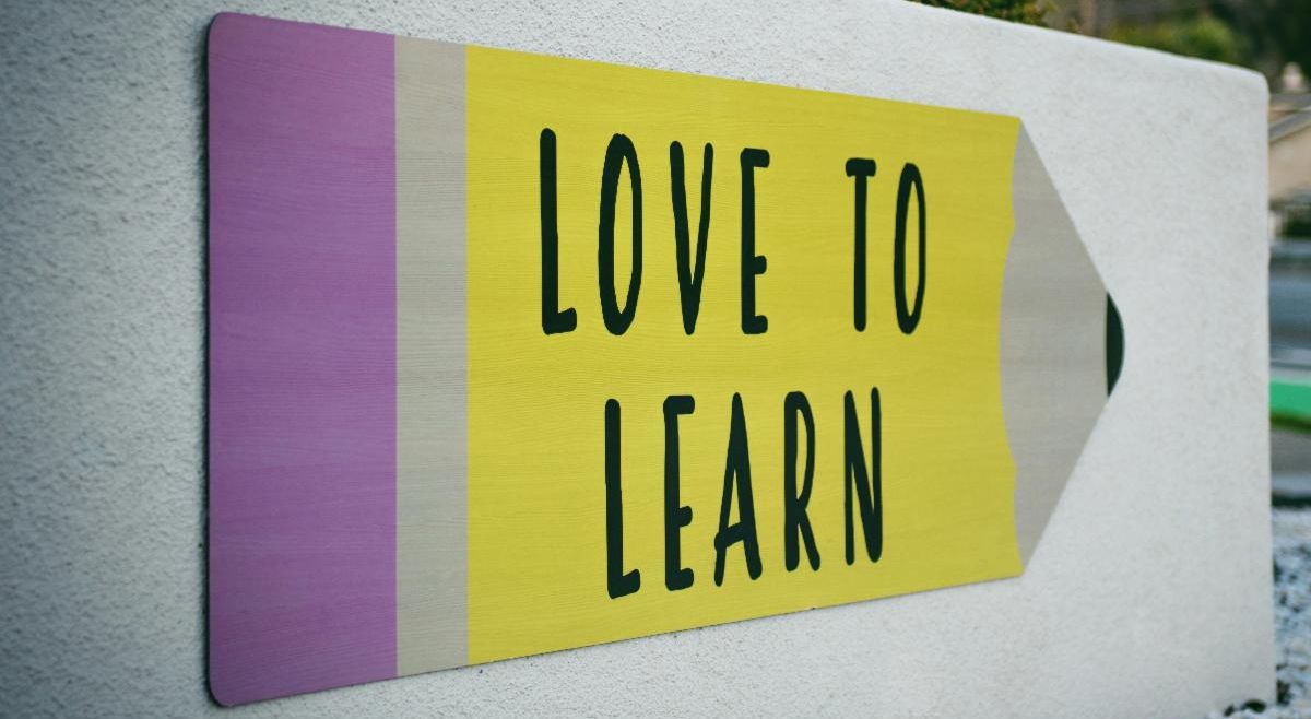 Love to Learn sign written on a giant pencil