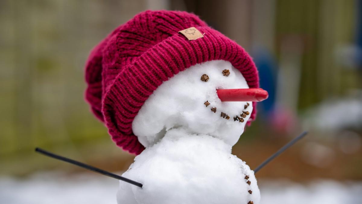 Snowman in a red hat with a crayon nose