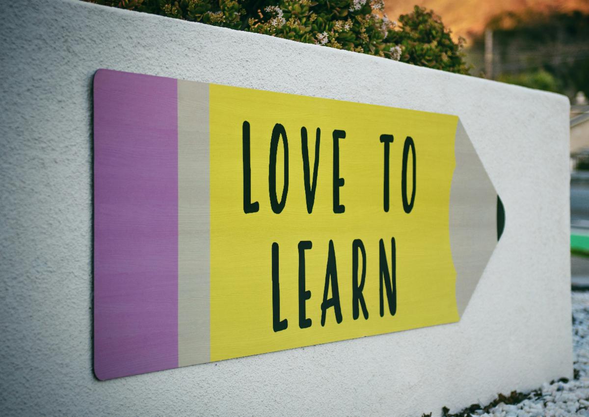 Love to Learn sign written on a giant pencil
