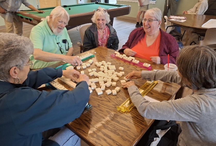 SAGE members sit around a table with mahjongg tiles on it