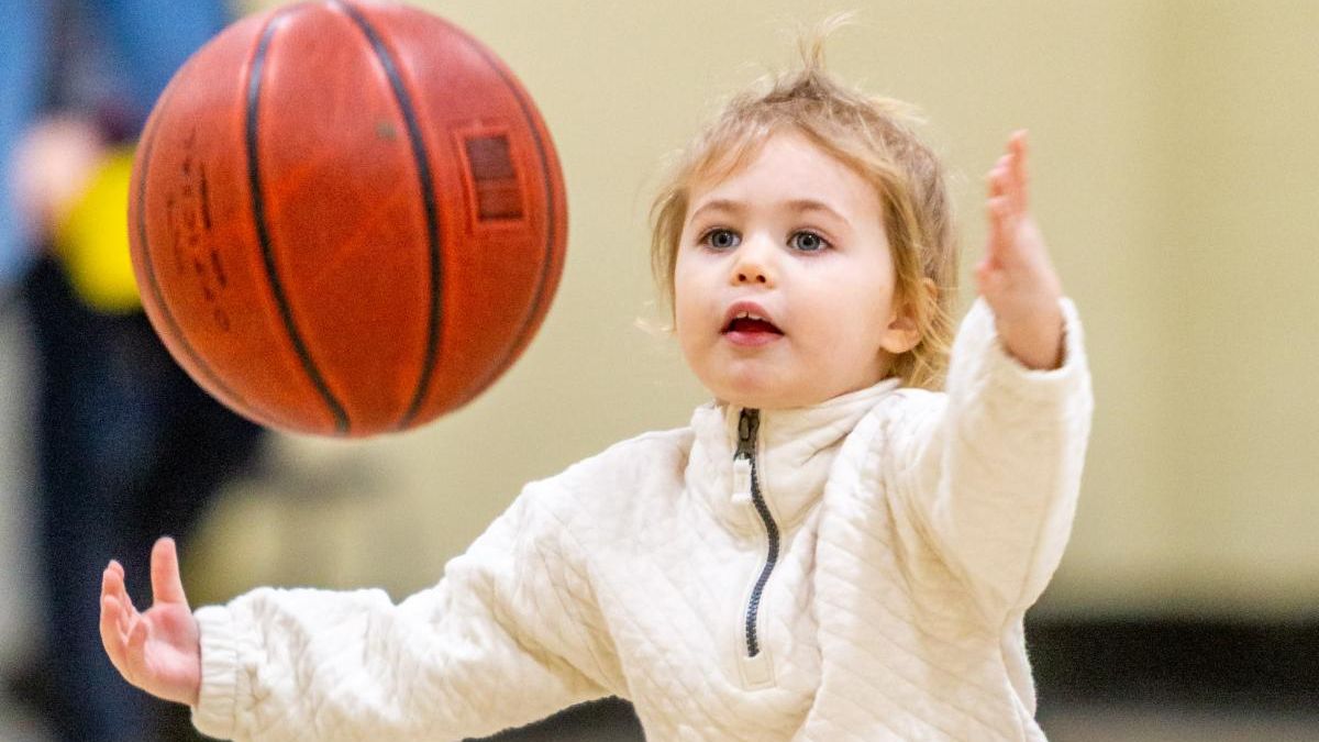 A young child plays with a basketball at the Port Weller Community Centre.