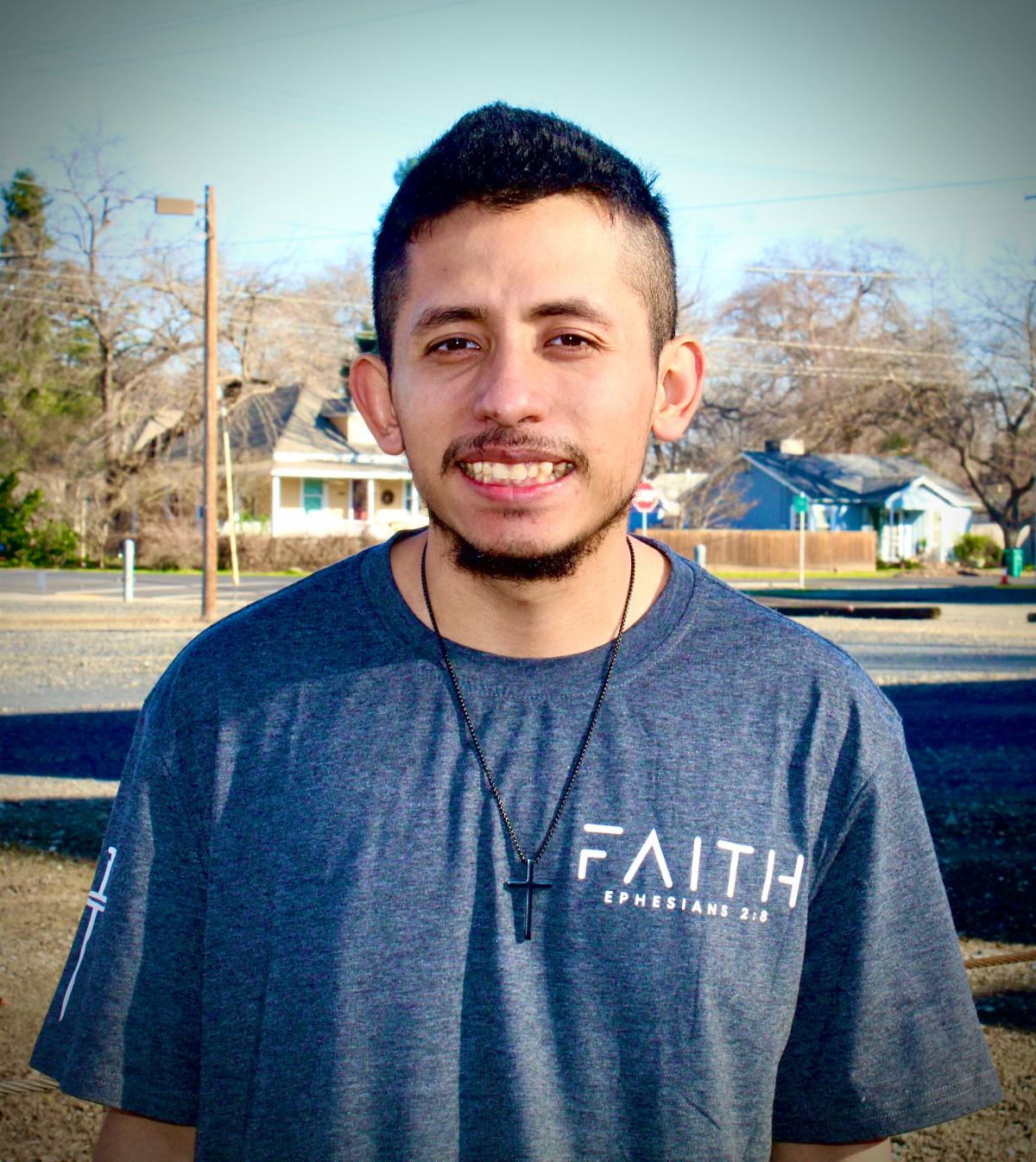 Joseph G. smiling and wearing a blue t-shirt.
