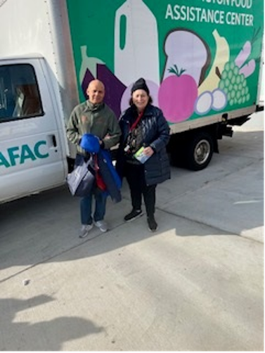 [Image: Miguel Fernández, a recently arrived Colombian assisting Rosalía Fajardo in front of the AFAC distribution truck].