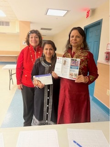 [Image: (Left to Right) Rosalia Fajardo, Ruchika Lalwani holding a Covid-19 test kit and Karuna Gulati holding an ECNV brochure].