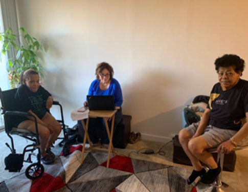 [Image: (Left to Right) An Afro-Latino woman sitting in a wheelchair, Rosalia Fajardo with a laptop, and an Afro-Latina woman sitting in a stool chair].
