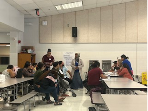 [Image: Fazia Deen Outreach Director for the Islamic Center (center) speaks to workshop attendees].  