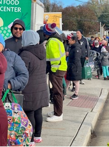 [Image: A line of Arlington residents waiting to be served]. 