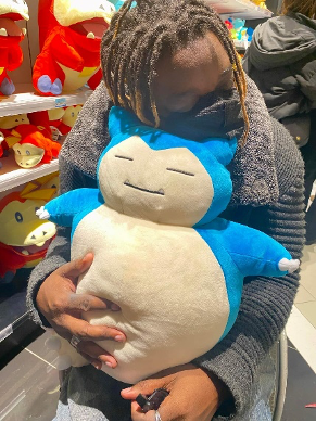 Traveling through Tokyo, these are pictures of various Pokémon including a graffiti of Mewtwo on the wall, and me hugging Snorlax, posing with my friend Erin in front of Temple torii gates and take a picture of the mirrored entrance to a fashion mall. 