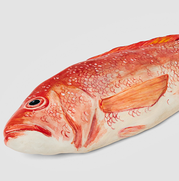 A detail of a ceramic red snapper sculpture