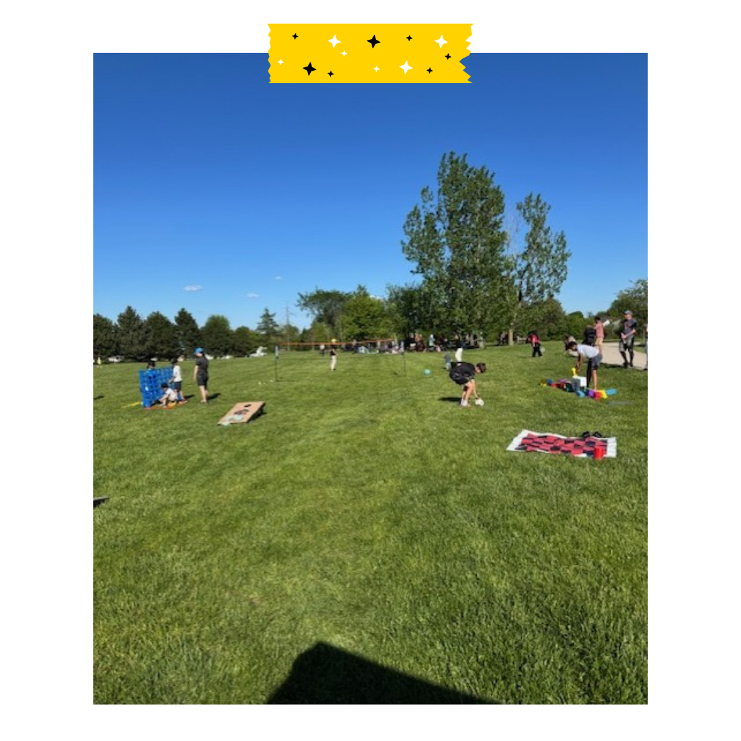 Lawn games set up on grass with neighbours playing with them.