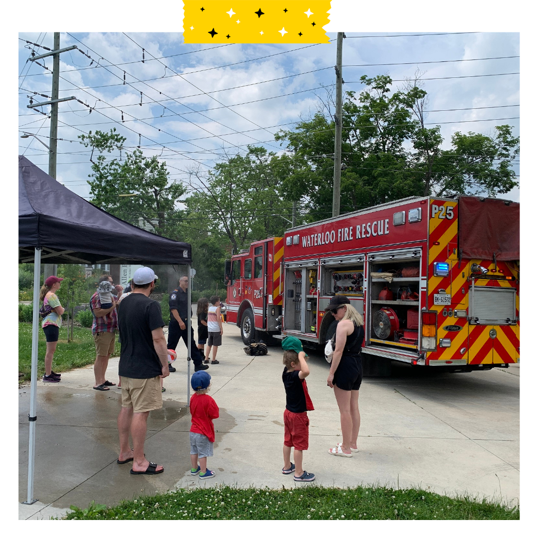 Firetruck in a park outside and neighbours standing around.