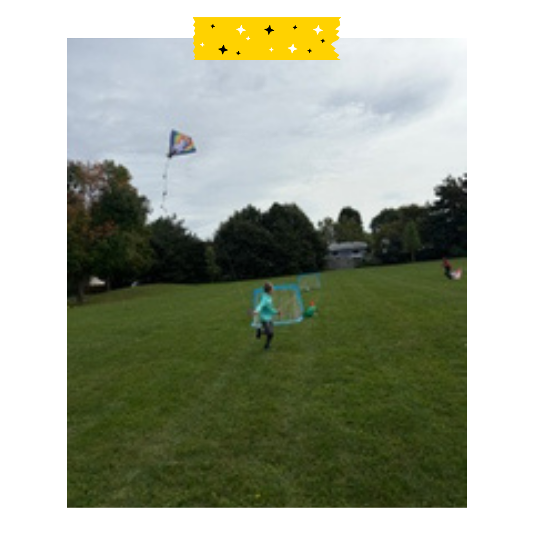 A child outside flying a kite in the green grass.