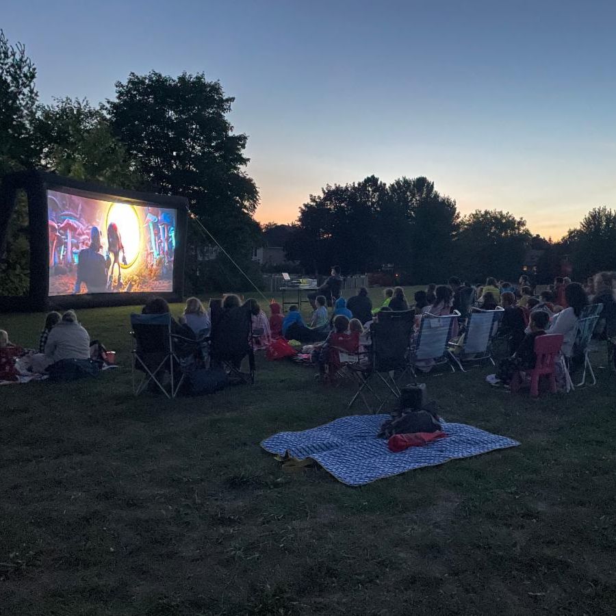 Large group of people watching a movie outdoors