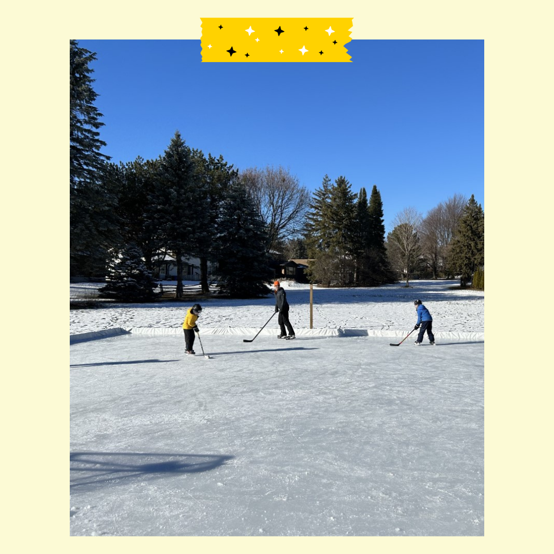 3 people on an outdoor rink in a park with hockey sticks