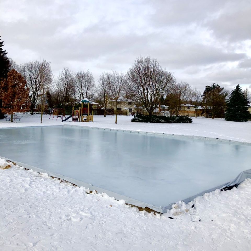 Outdoor skating rink on a winter day with snow surrounding rink
