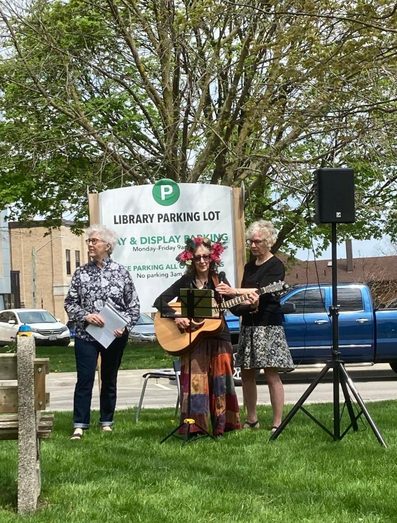 Three people playing instruments and performing outdoors