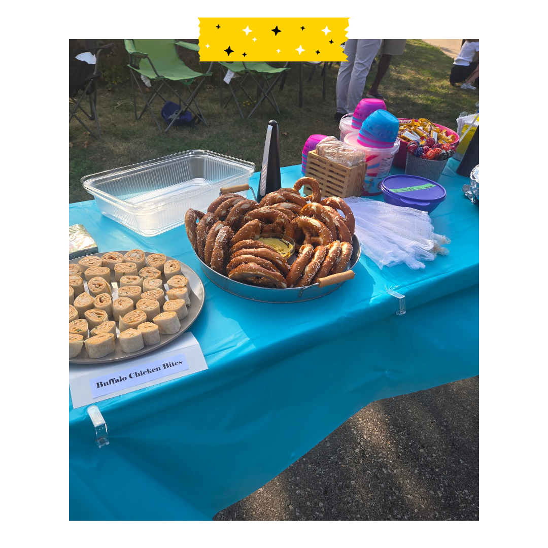 Food on a table outside with pretzels and pinwheel chicken sandwiches.