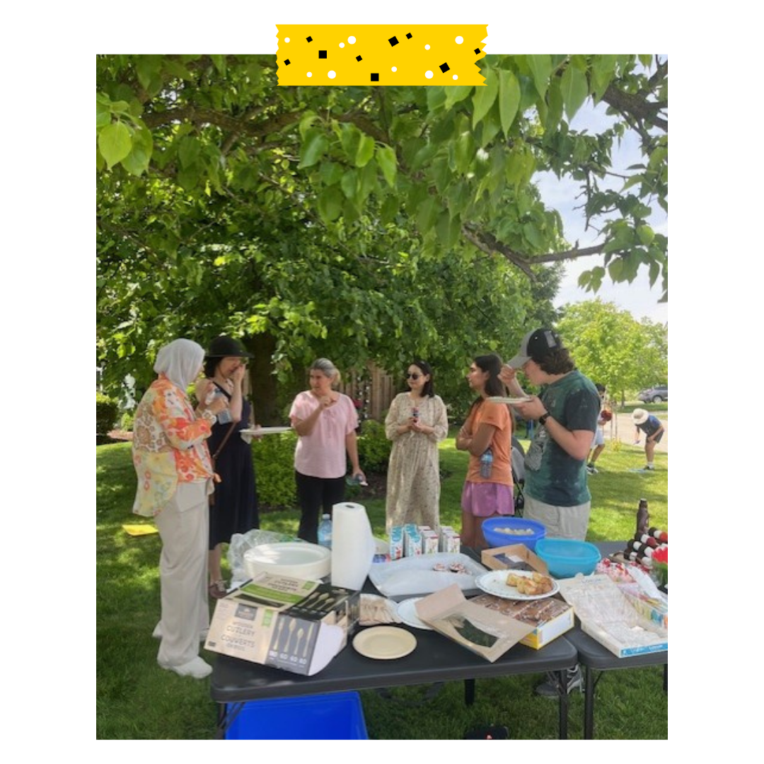 People standing with plates in their hand and eating food outside.