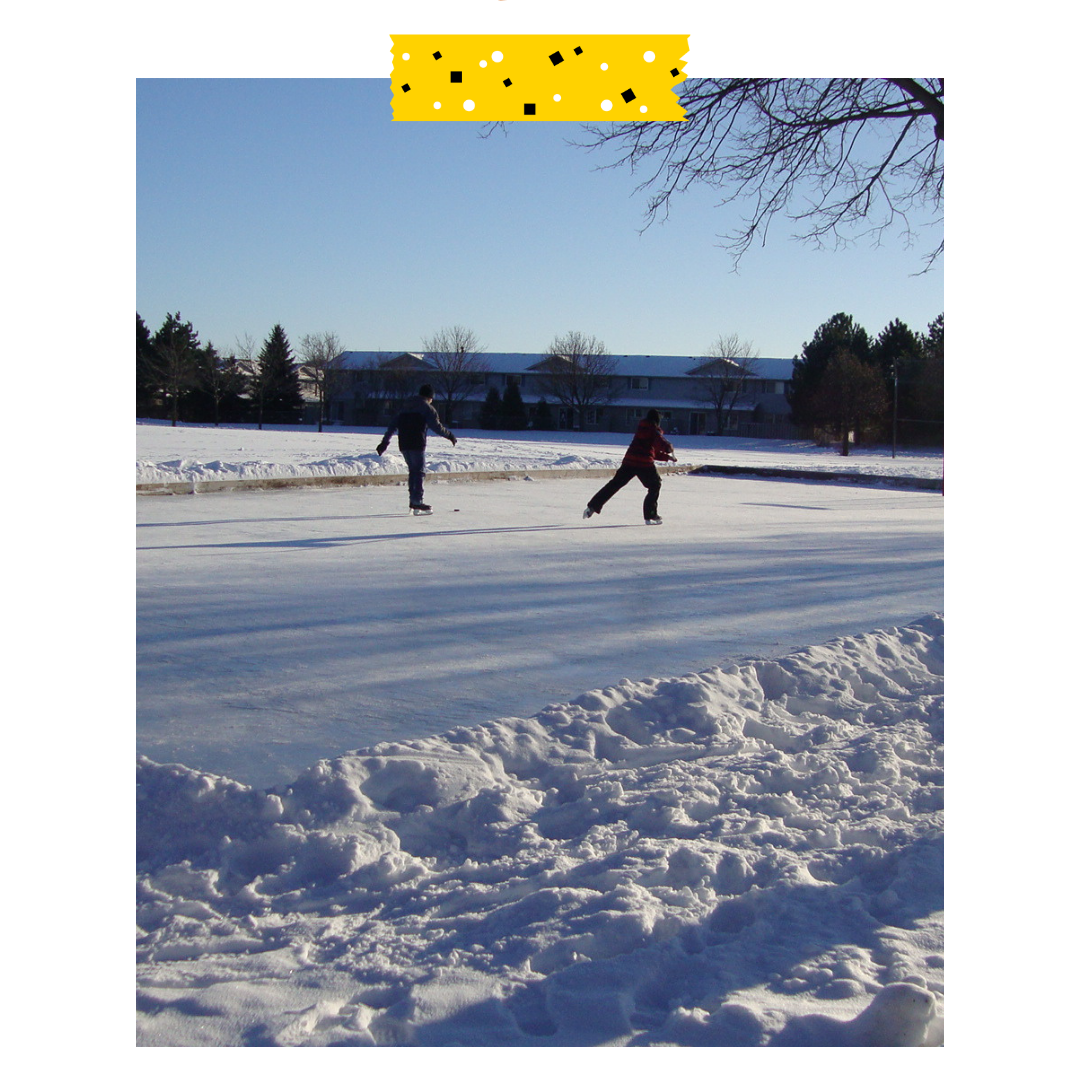Two people outside on an outdoor rink skating.