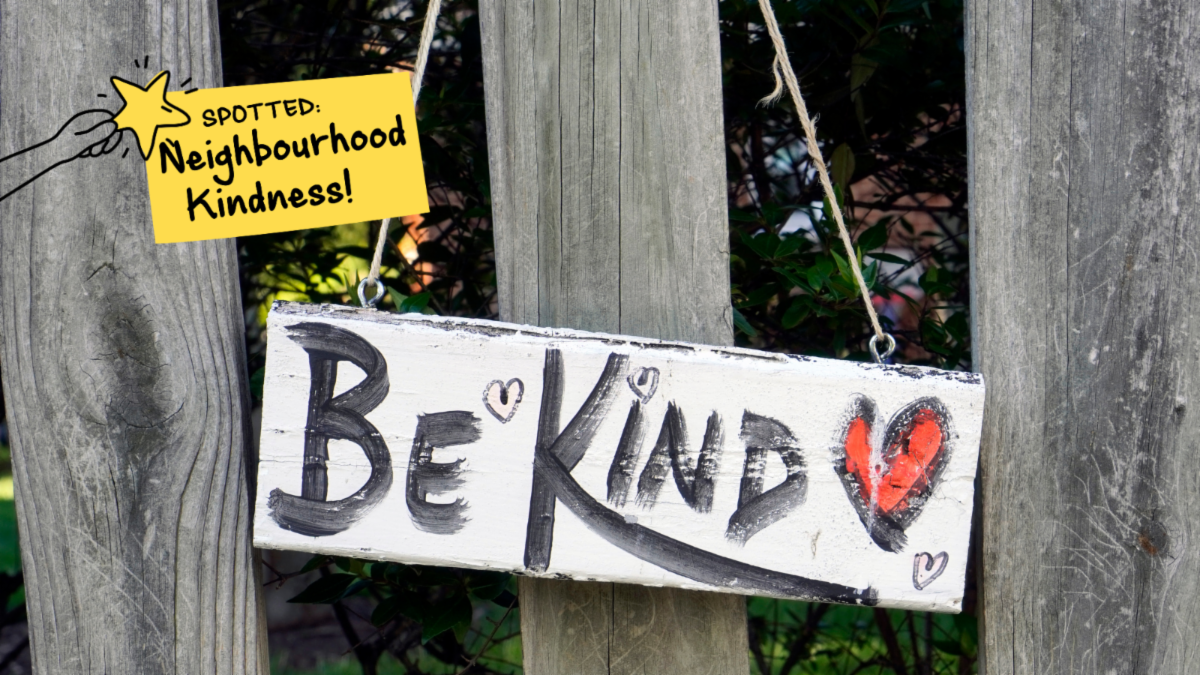 Handpainted sign on wooden fence that reads Be kind