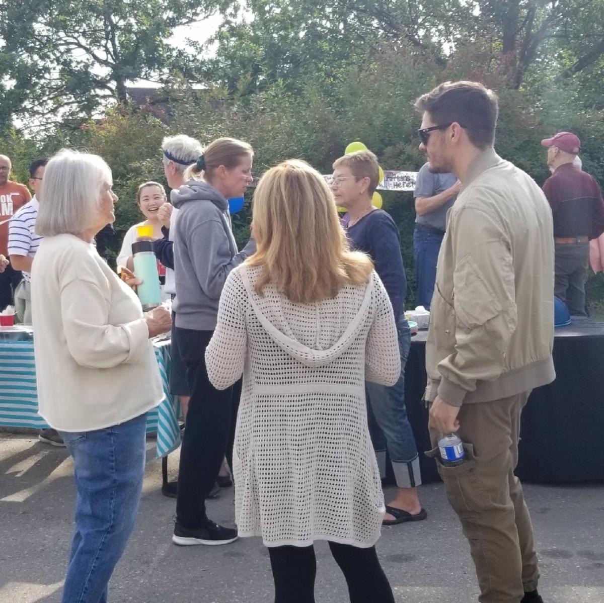 Group of people standing outside talking at an event