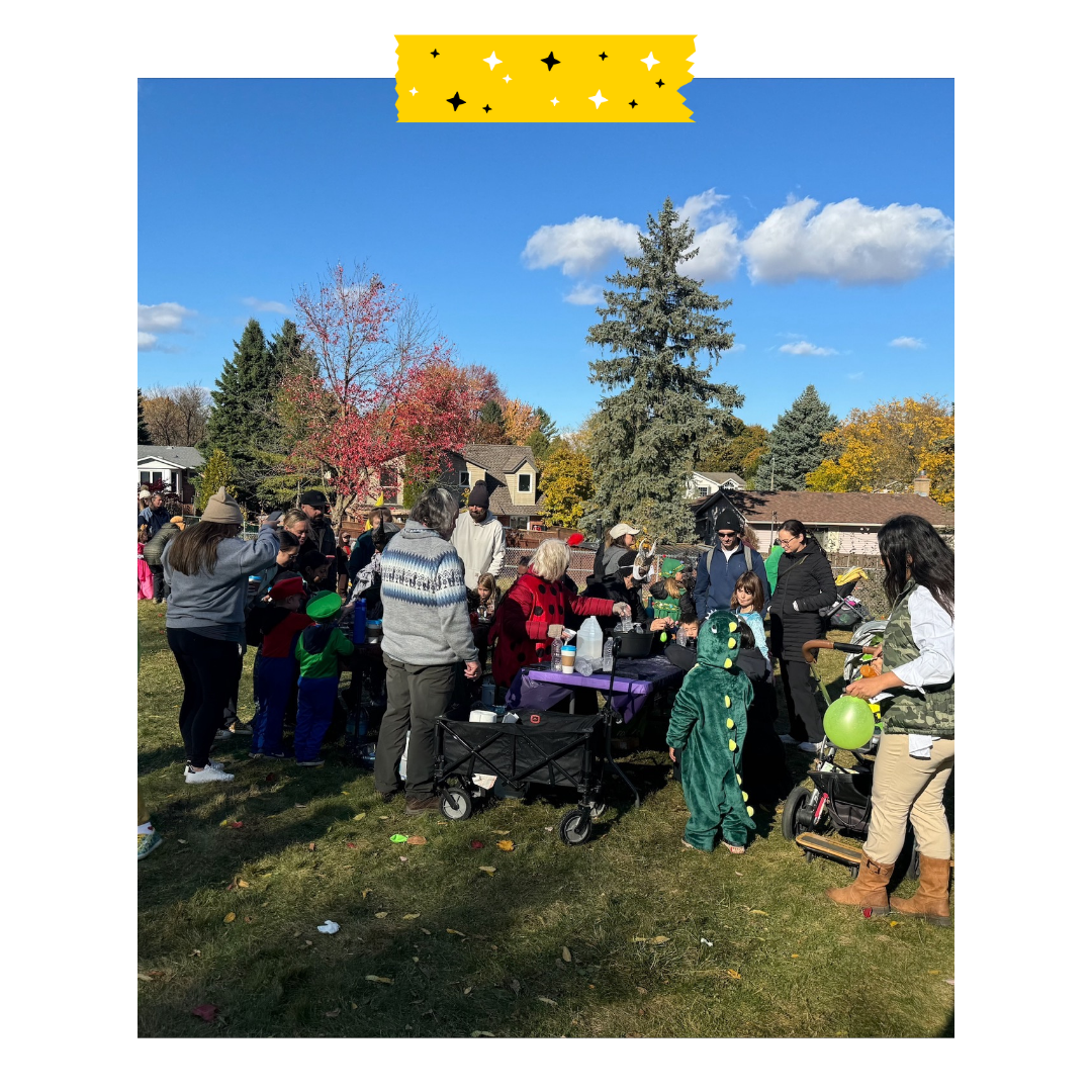 People in Halloween costumes outside around a table.
