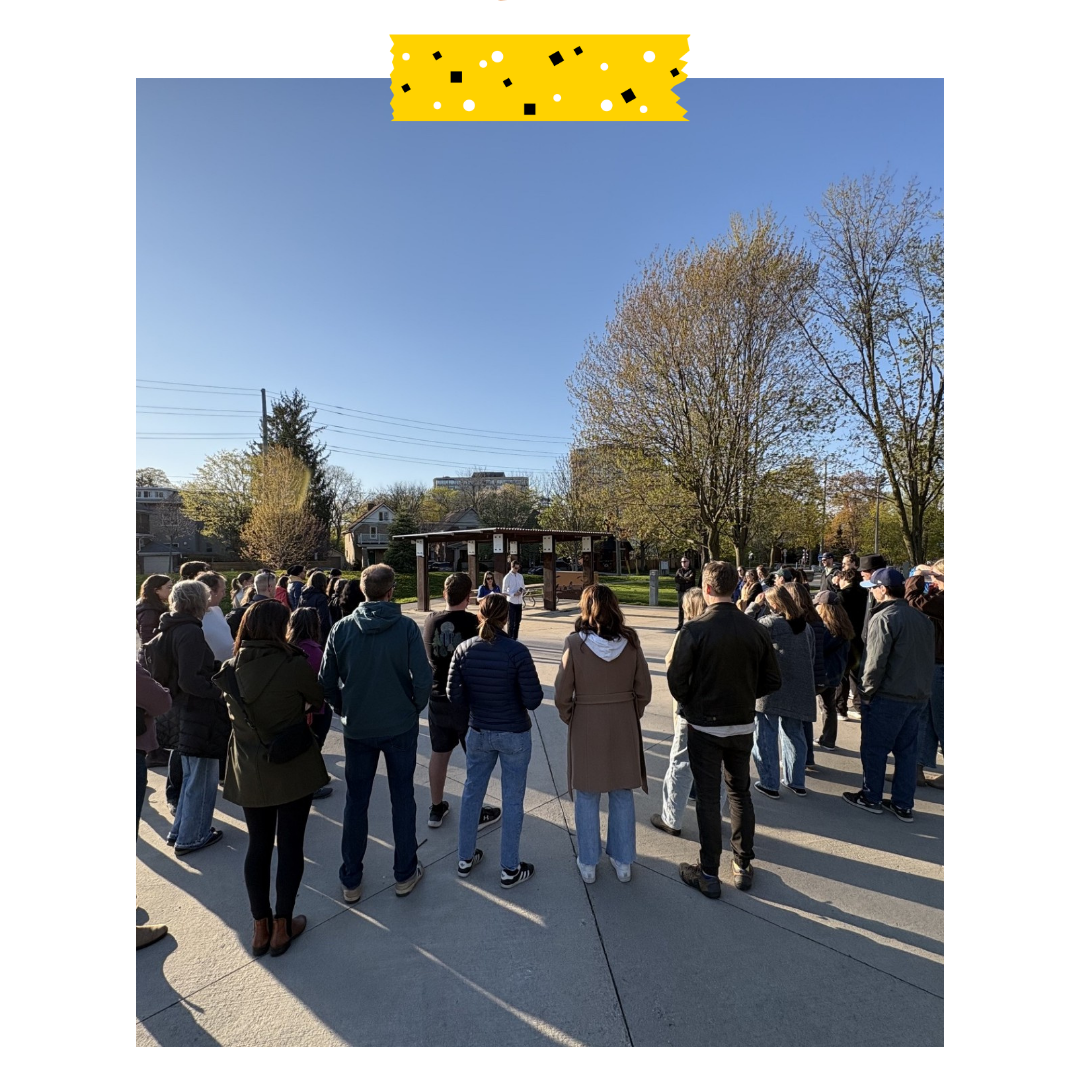 People standing outside in a circle in a park.