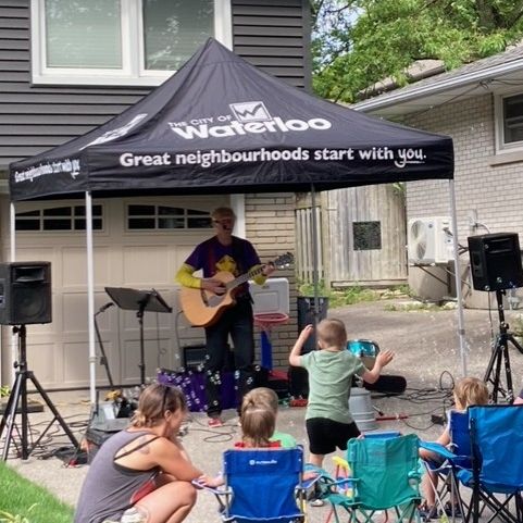 Person playing a guitar with people watching 