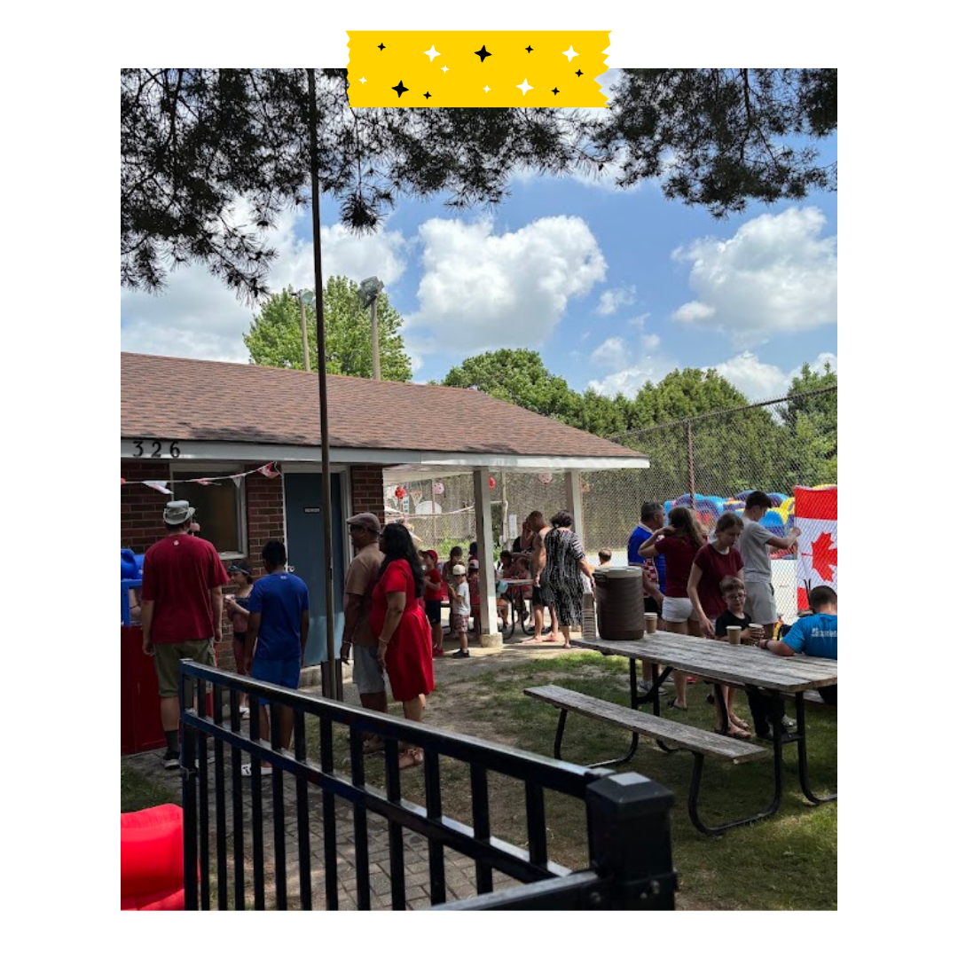 People outside sitting and standing and talking and enjoying food.