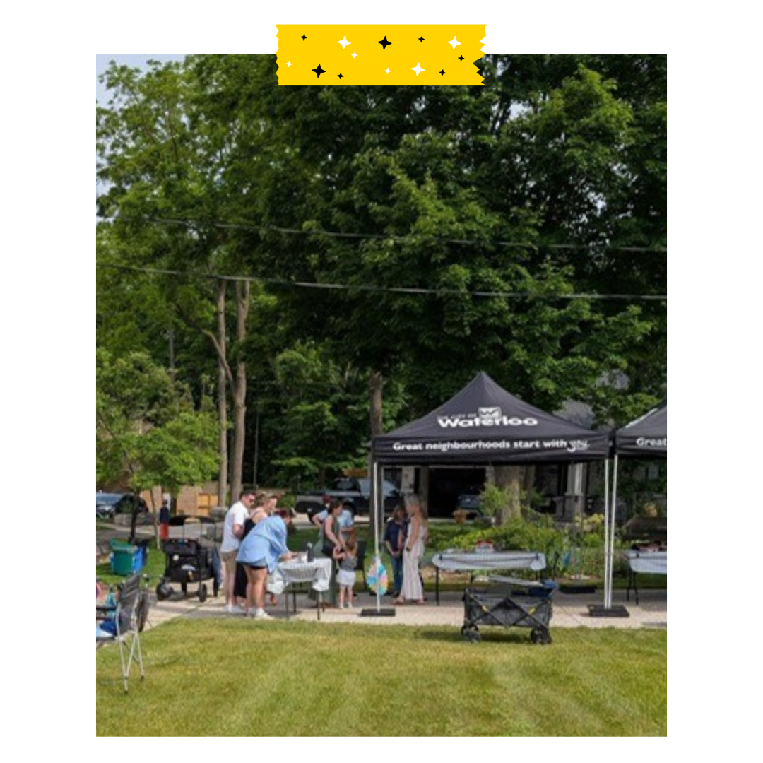 Outdoor event with a Waterloo neighbourhoods tent and people around it 