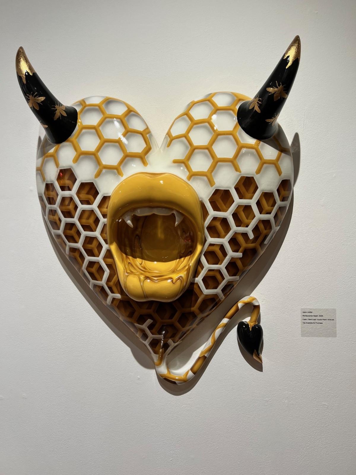 Heart sculpture with horns painted like a honeycomb in the art gallery