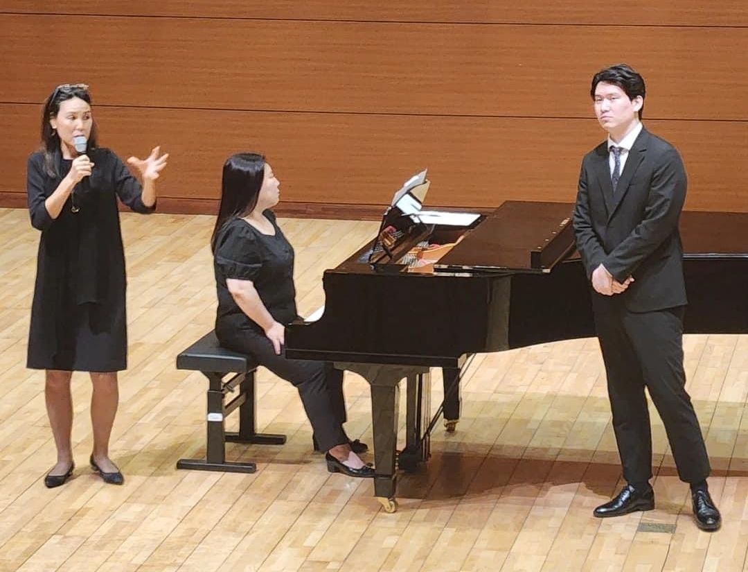 Dr. Jung and two students by a piano