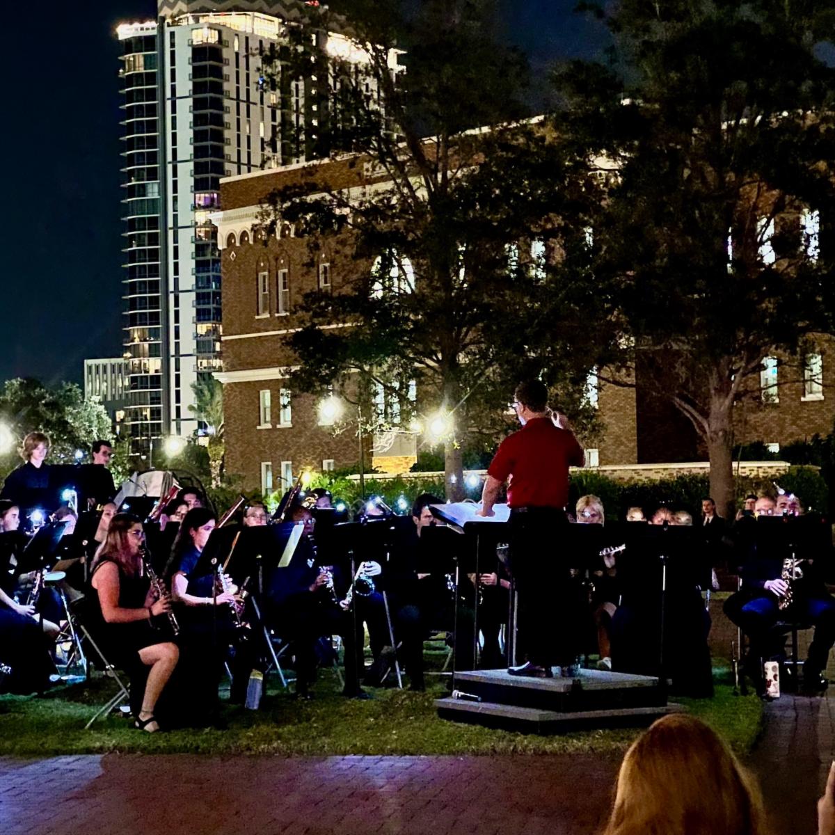 Dr. McDannald conducting the band at night in Sykes Plaza