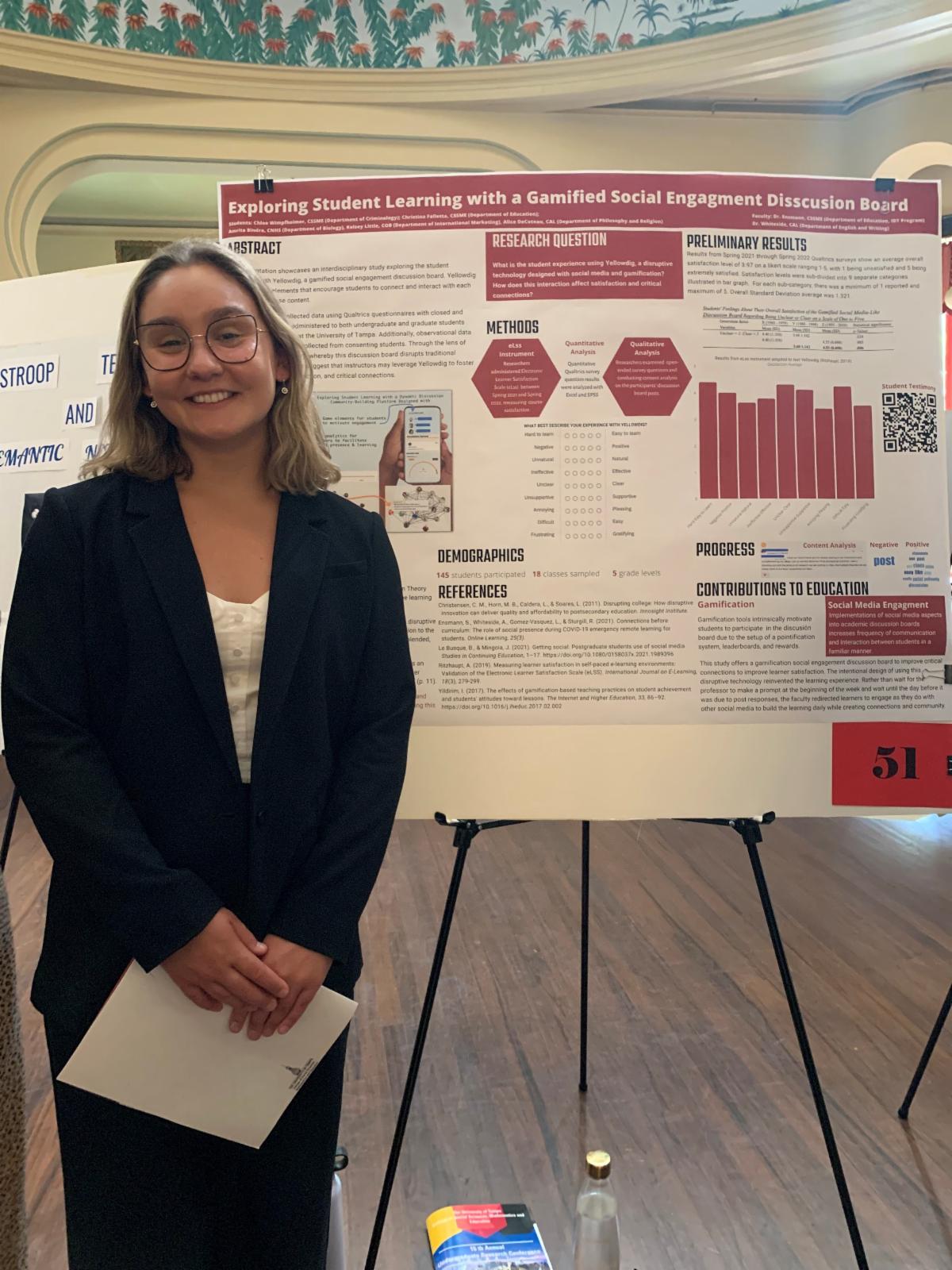 Alice DeCoteau in business wear standing in front of a research poster
