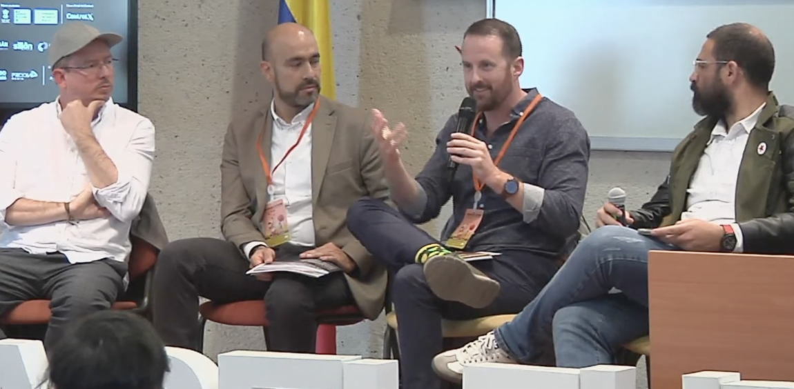 Panel discussion of four men. Dr. Christopher Boulton is speaking