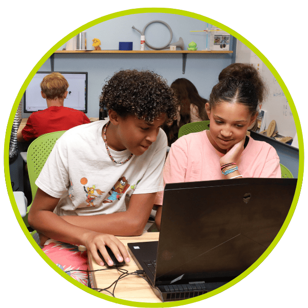 Young male and female teens sitting at a computer working on animations.